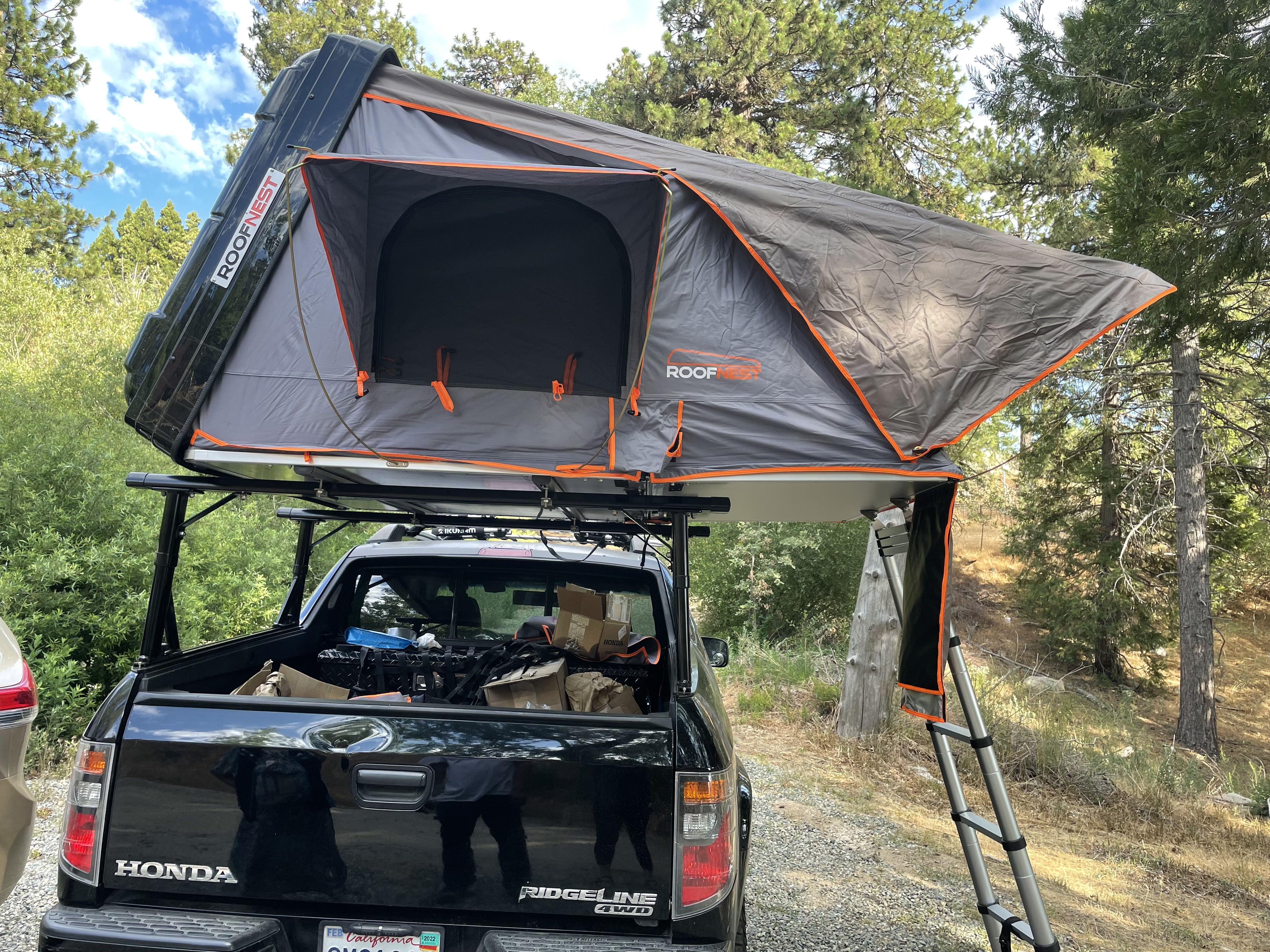 A rooftop tent on top of a black truck.